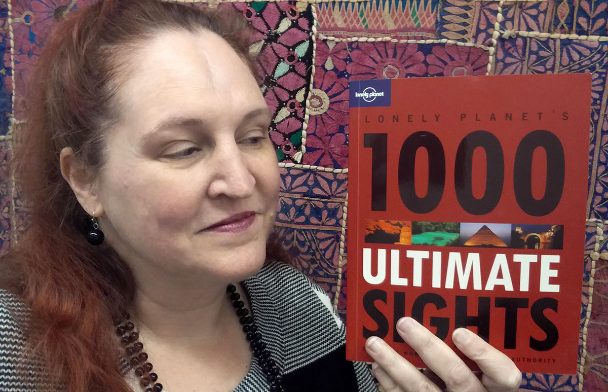 Carma holding a copy of Lonely Planet’s 1000 Ultimate Sights