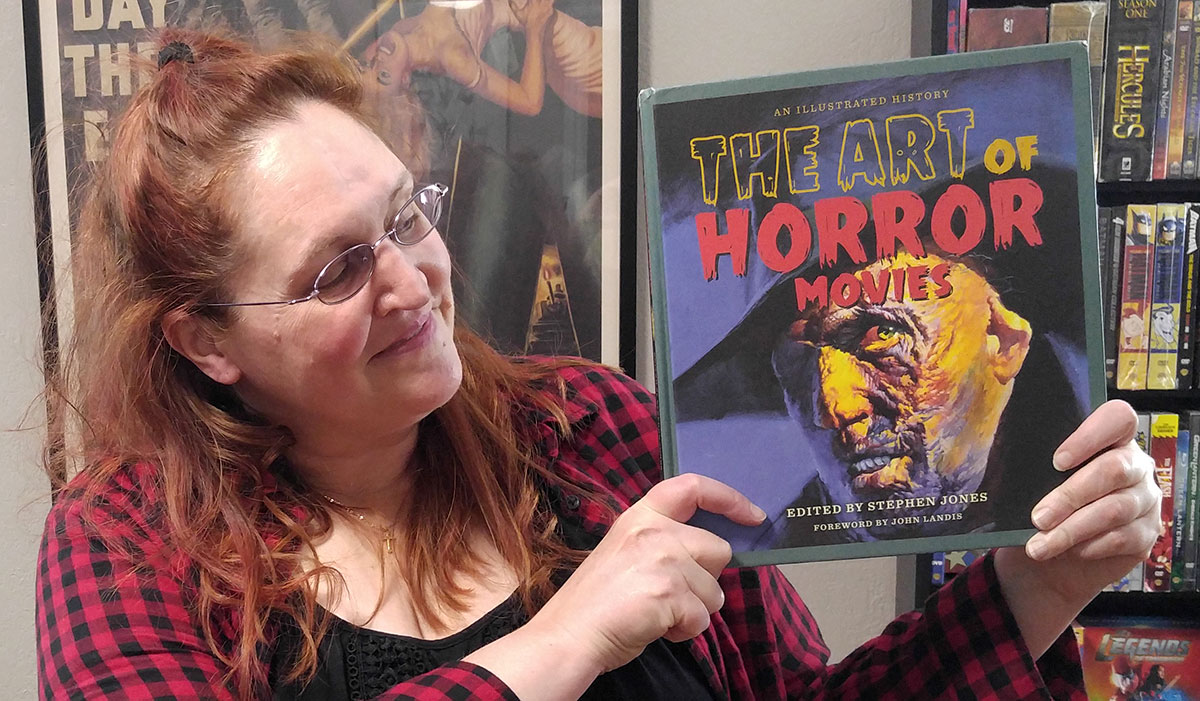 Carma Spence holding a copy of “The Art of Horror Movies” by Stephen Jones