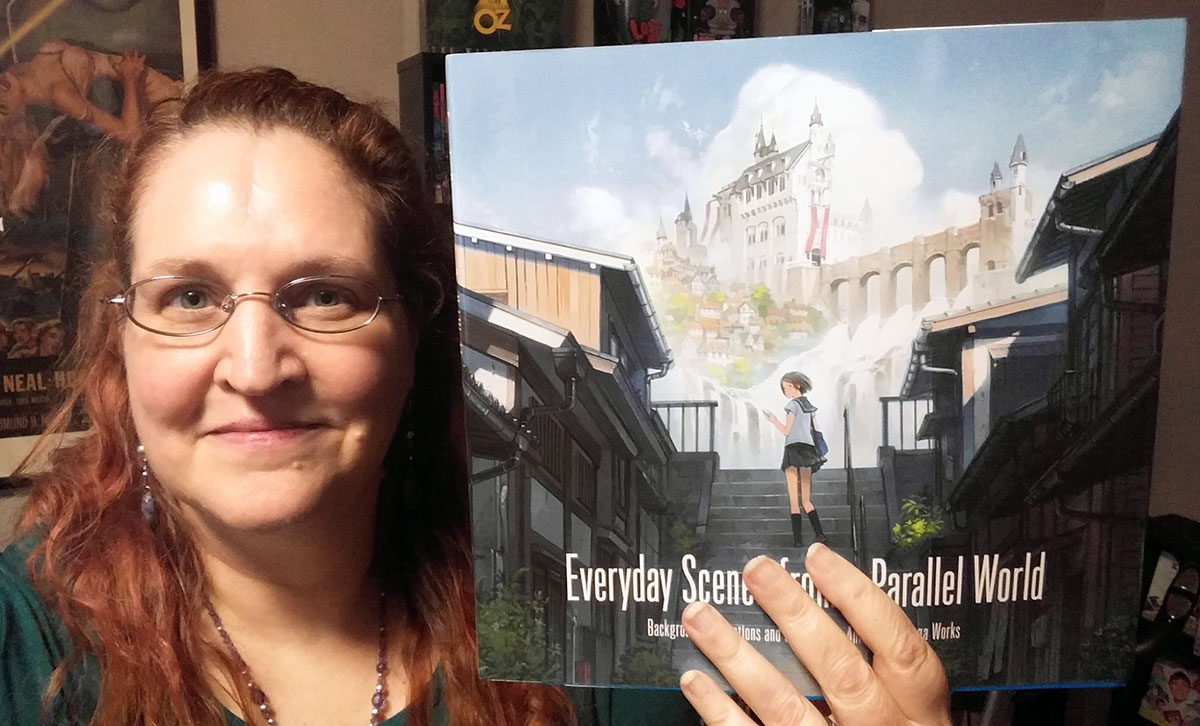 Carma Spence holding a copy of Everyday Scenes from a Parallel World