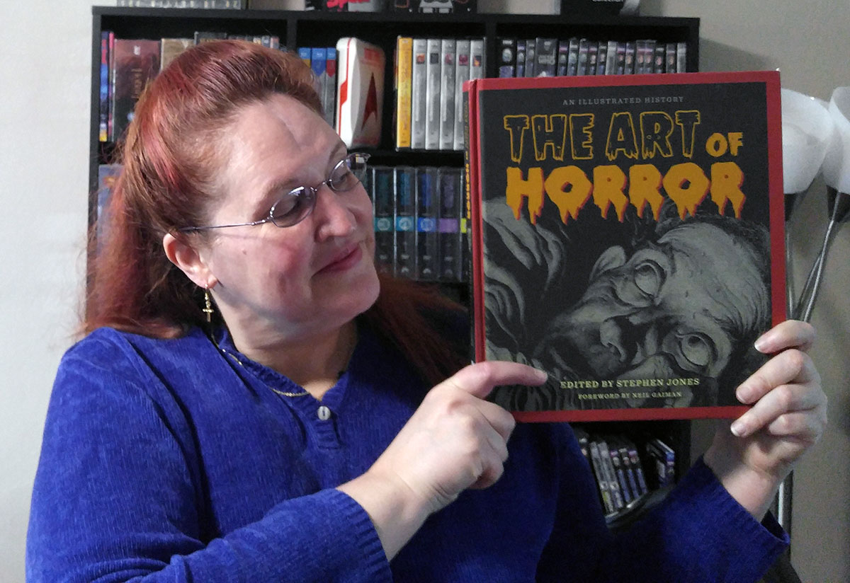 Carma holding a copy of The Art of Horror by Stephen Jones