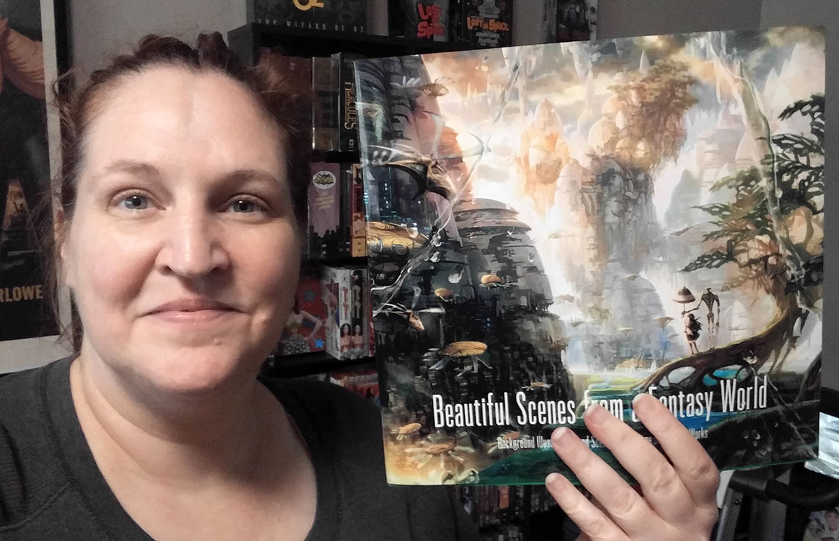 Carma Spence holding a copy of Beautiful Scenes from a Fantasy World