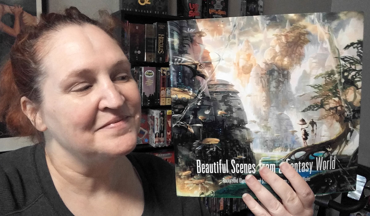 Carma Spence holding a copy of Beautiful Scenes from a Fantasy World