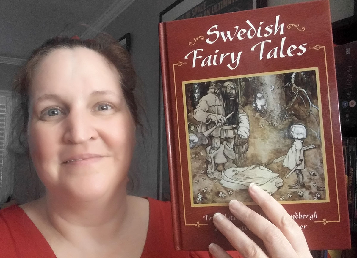 Carma Spence, The Genre Traveler, holding a copy of Swedish Fairy Tales