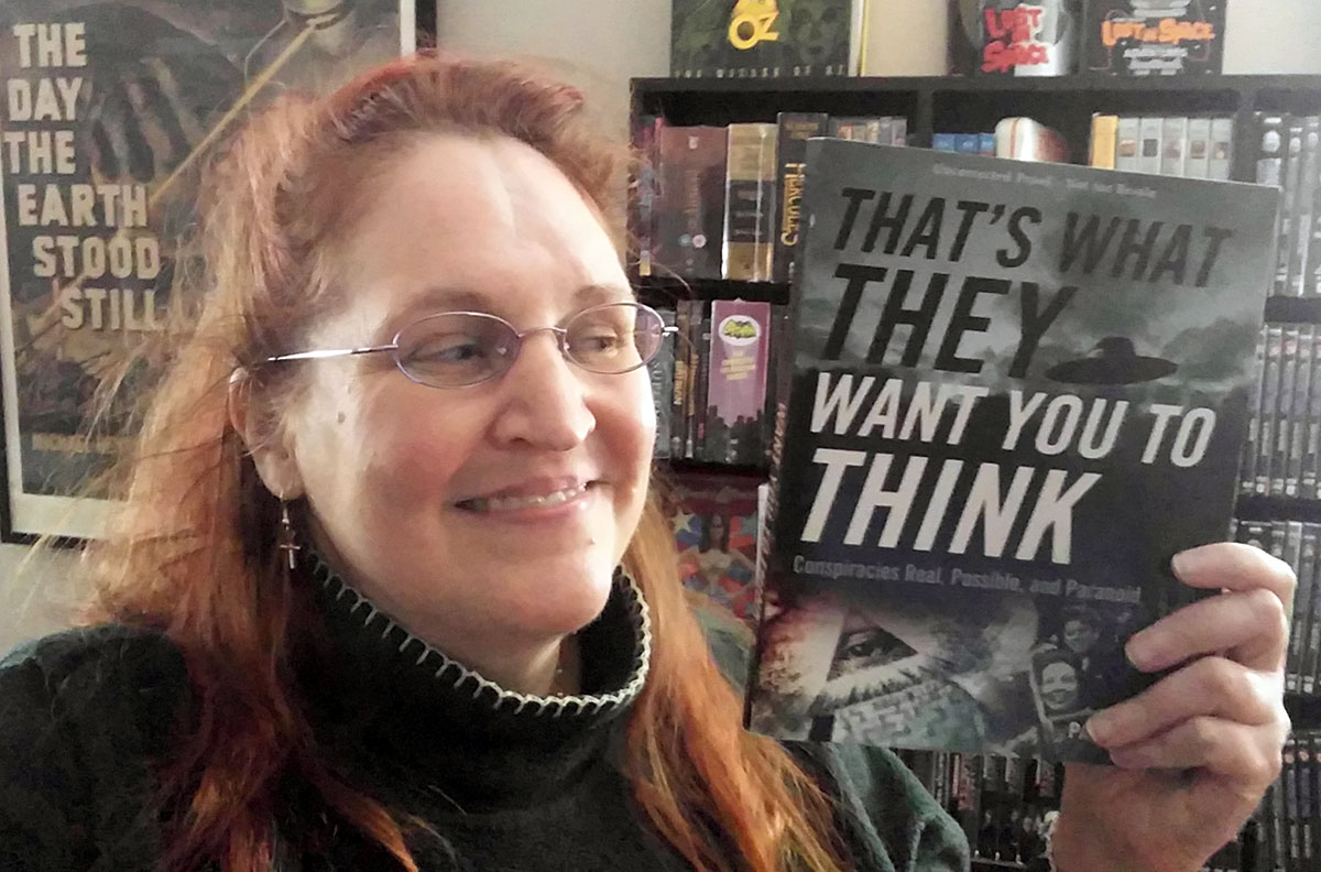 Carma Spence holding a copy of “That’s What They Want You to Think” by Paul Simpson